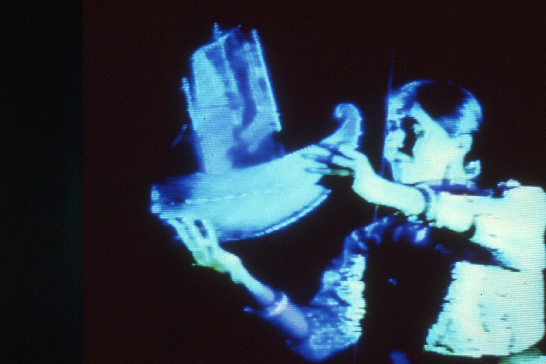 blue image of a person holding a toy ship