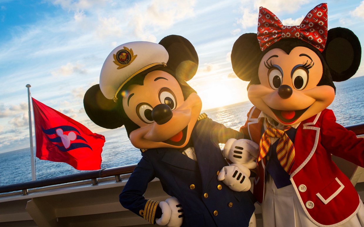mickey mouse and minnie mouse on a boat with the disney flag in the background