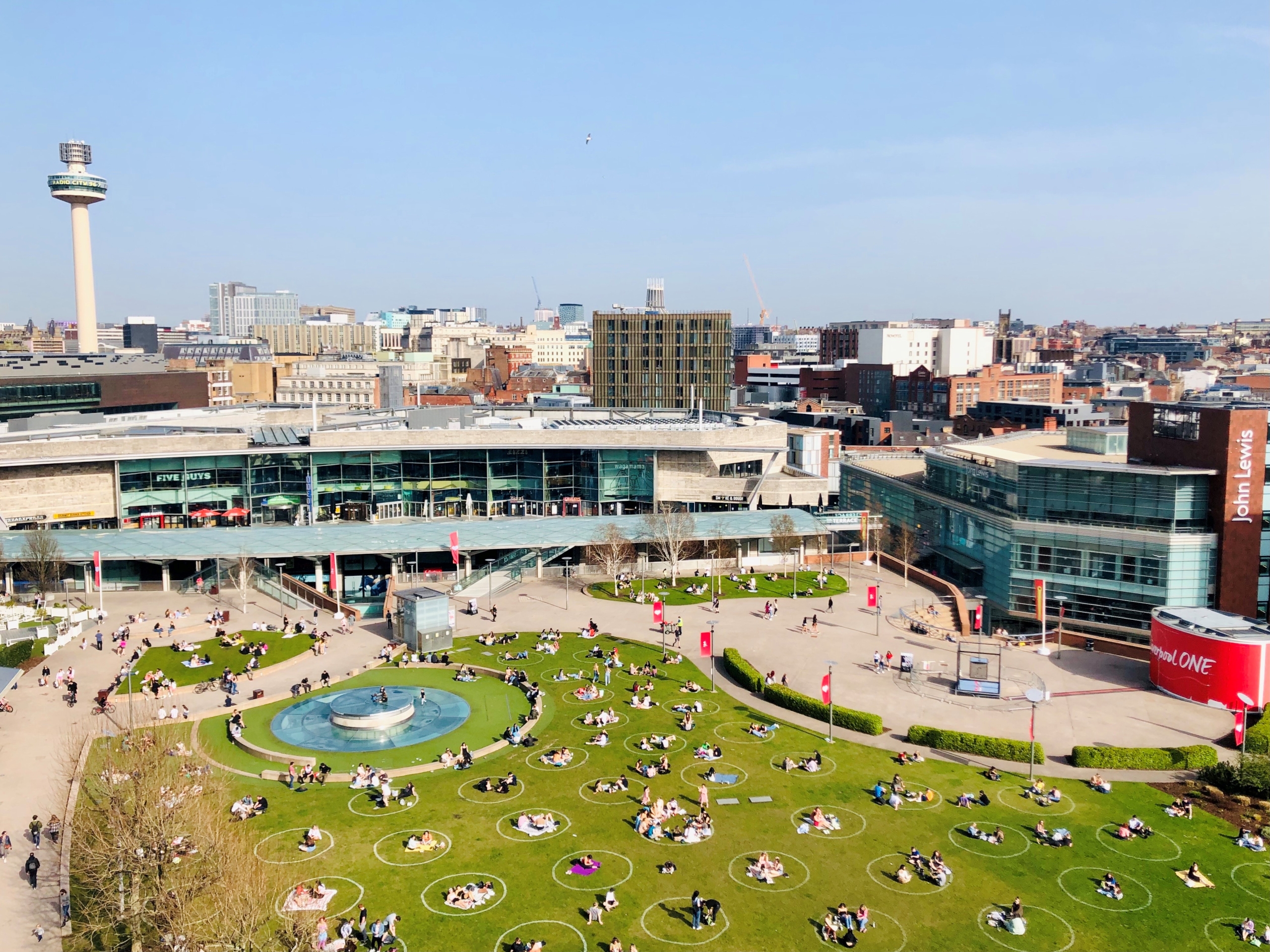 liverpool one chavasse park with distance safe circles drawn on the grass and public among them