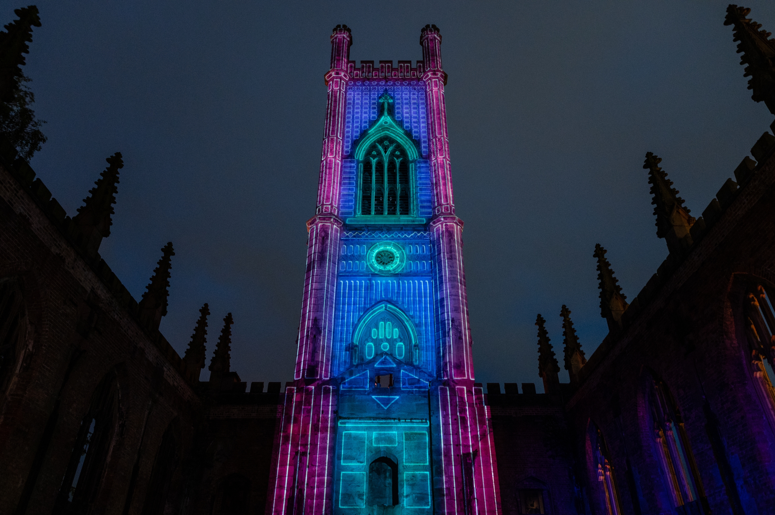 LightNight at Bombed out church featuring the church tower at night lit up in blue and purple