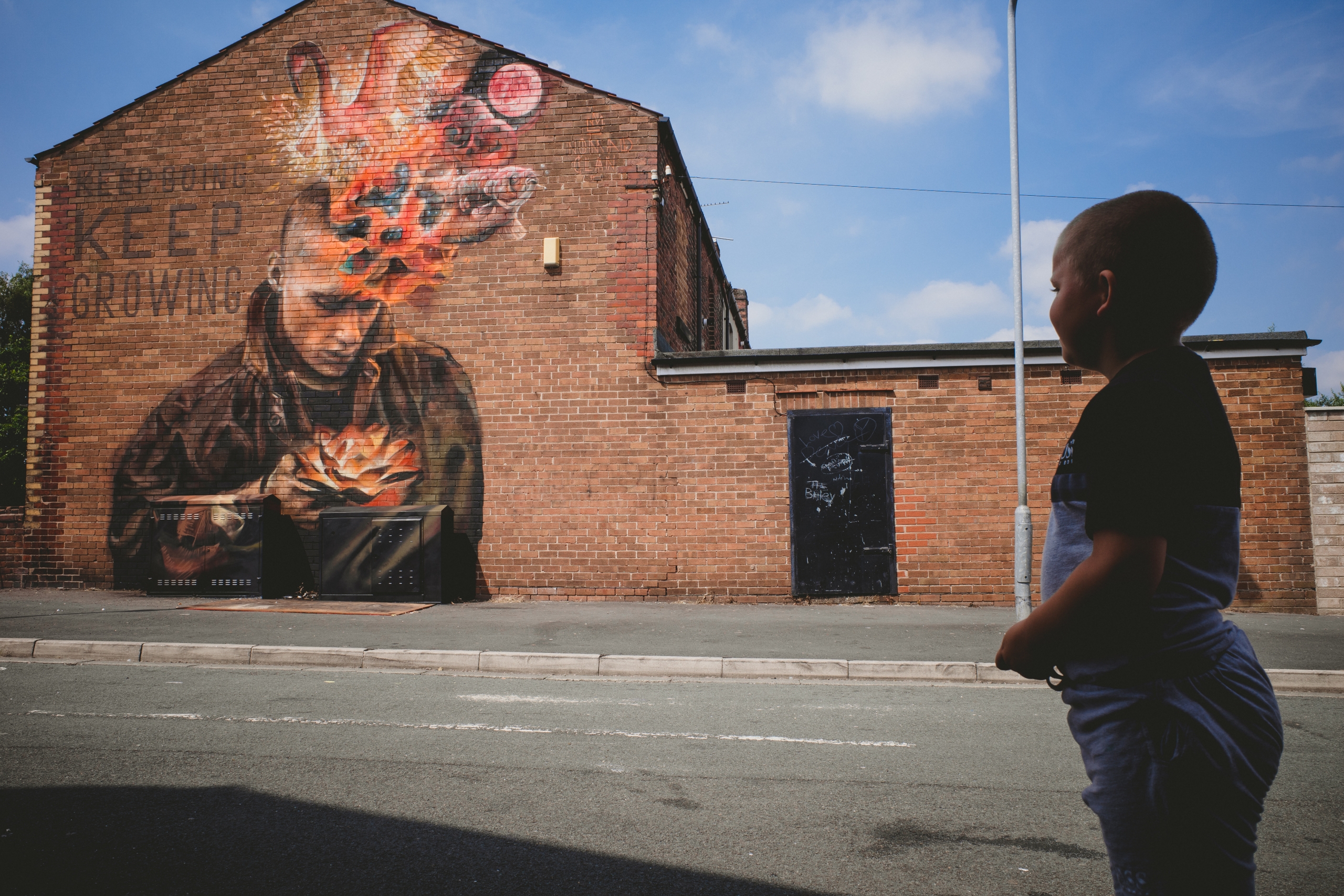 child looks at mural artwork on wall in st helens