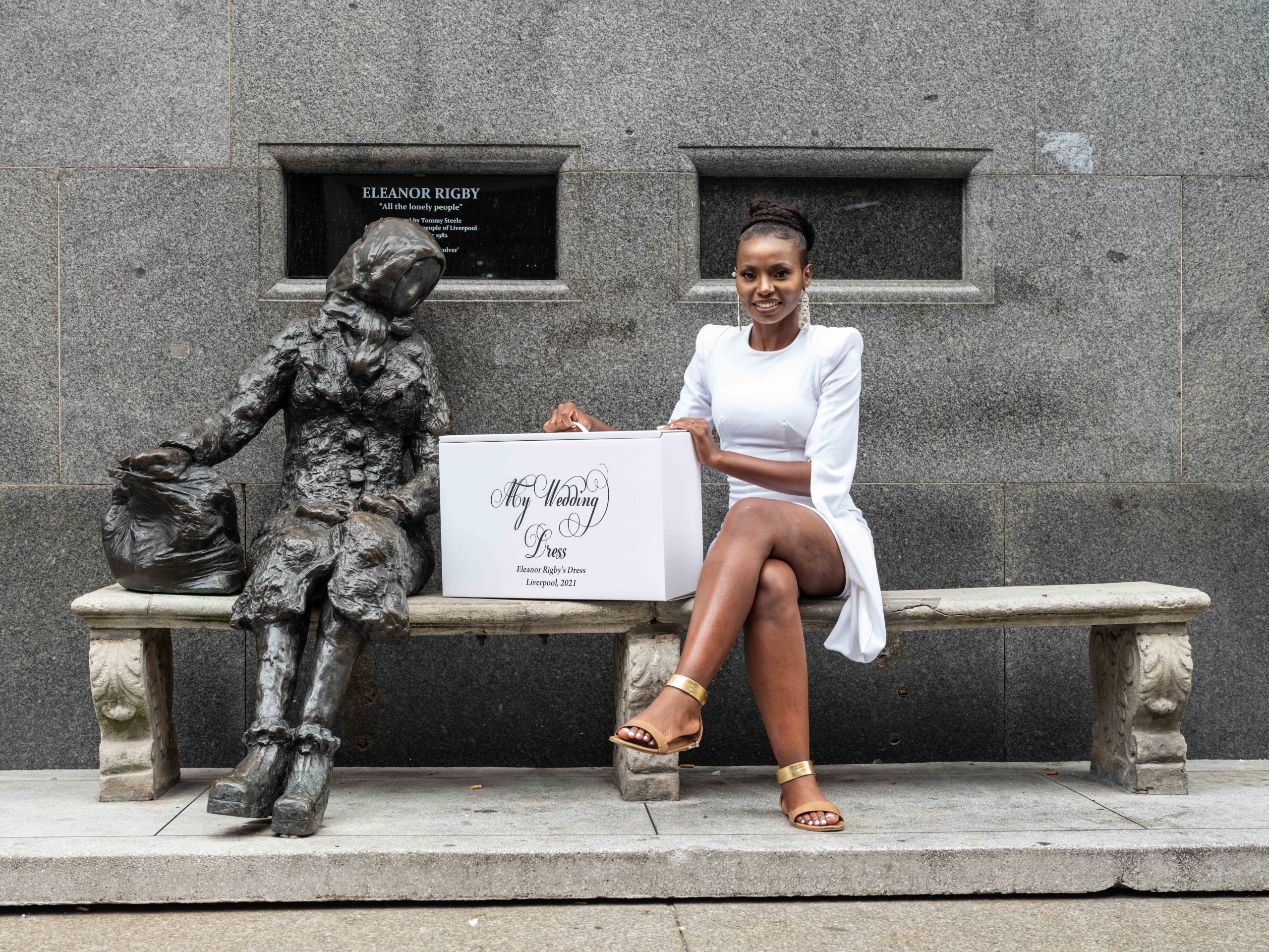 artist Taya Hughes sat next to the statue of eleanor rigby