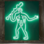 neon green outline of a male holding a stick as part of radical landscapes exhibit