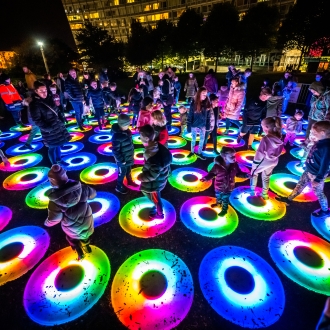 the pool light installation numerous coloured circles with people jumping on them