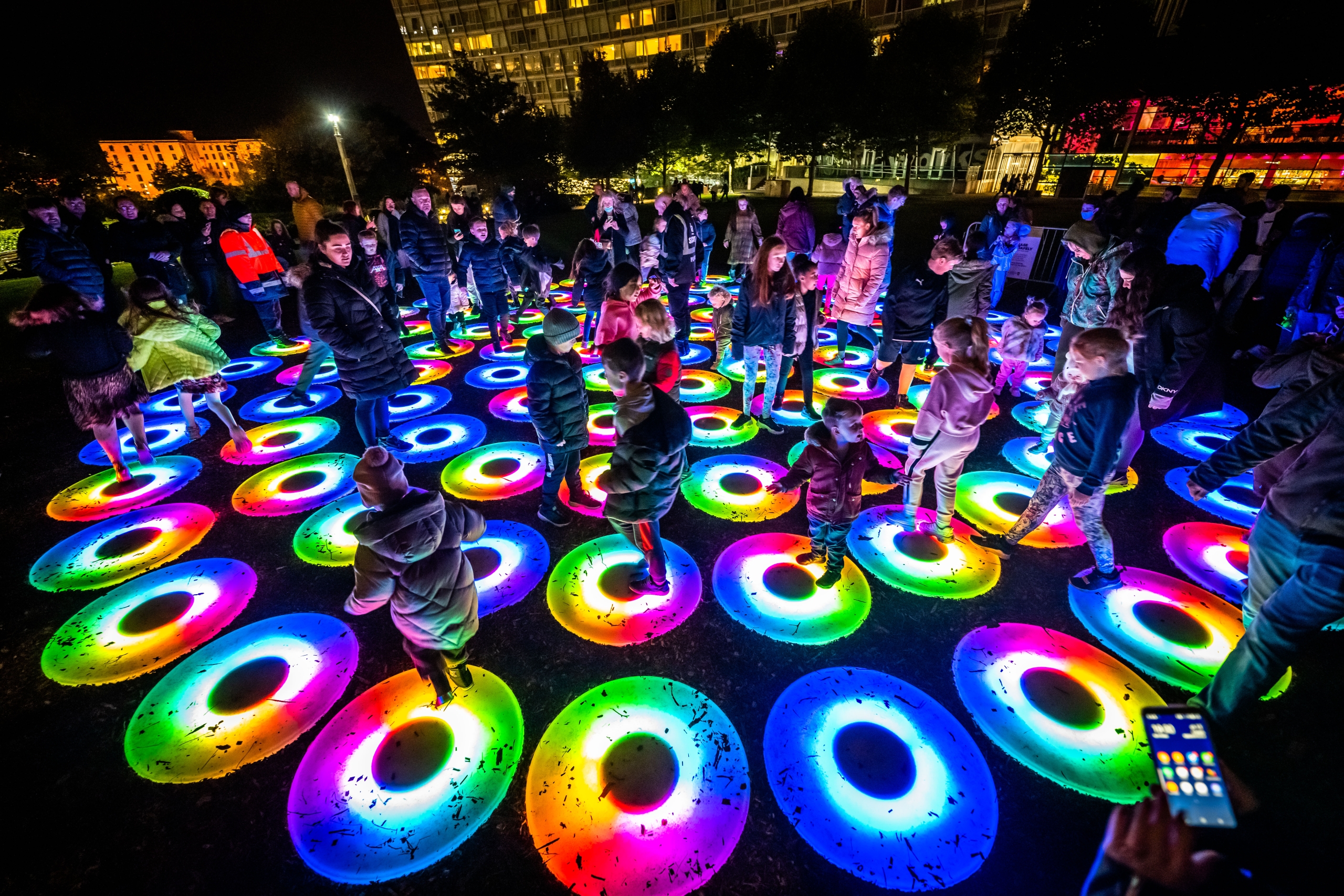 the pool light installation numerous coloured circles with people jumping on them