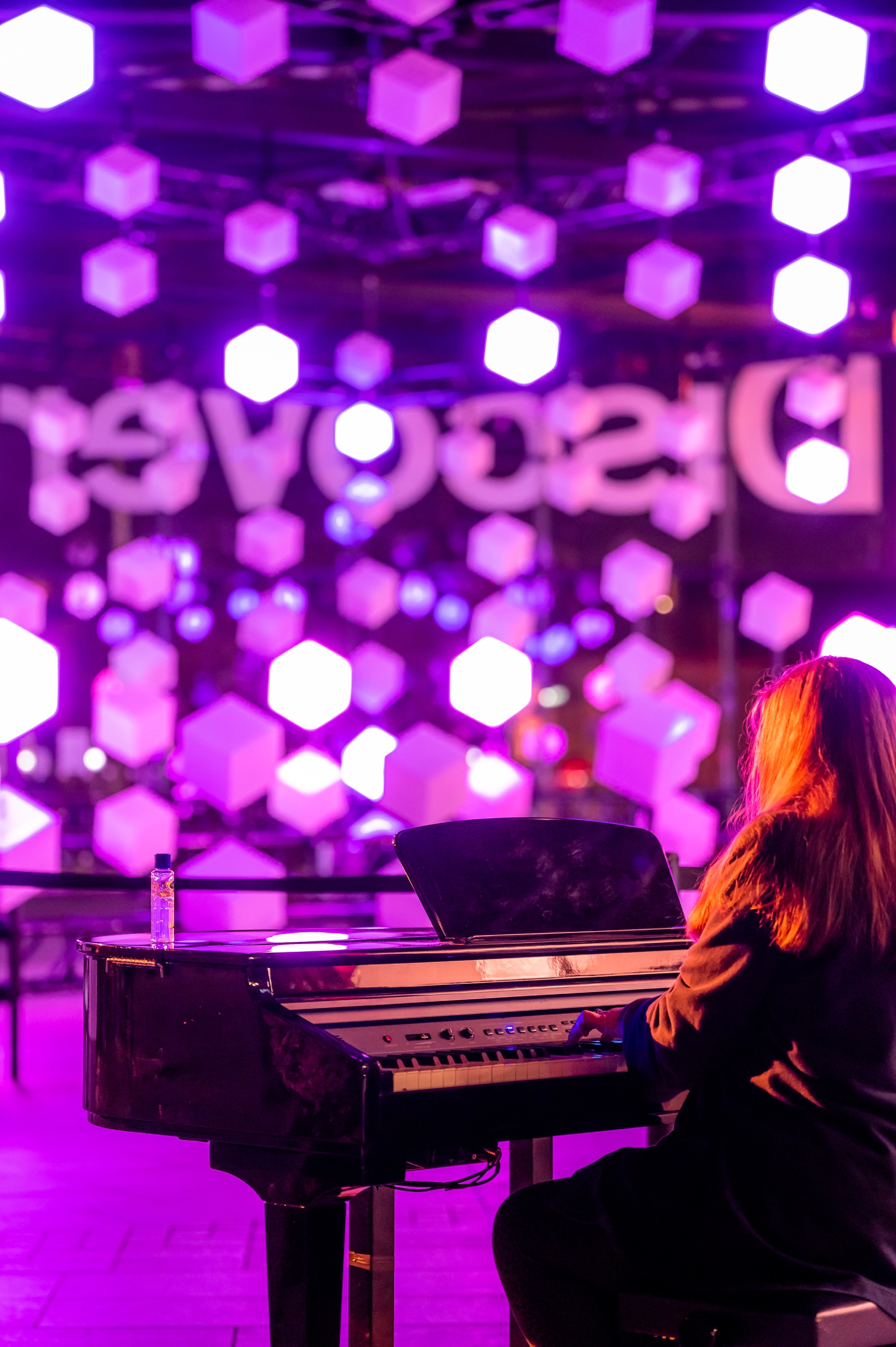 pianist at piano with purple shaped blocks suspended in front of them
