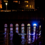 canal featuing stained glass windows with a light coming through behind at night