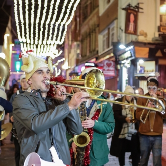 people in fancy christmas dress playing musical instruments at night performing