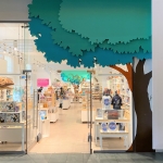 view of museum shop through a glass frontage and a giant cartoon tree outside showing christmas stock