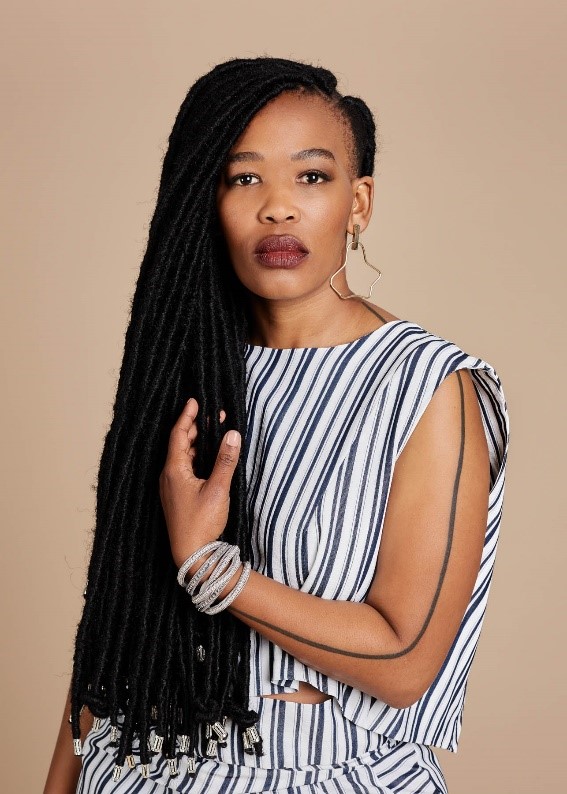 Khanyisil looking at the camera, in a blue and white striped top