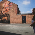 small child looks on to mural on a wall in st helens