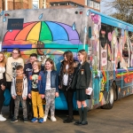 ARRIVA bus featuring colourful art over exterior with young people stood in front of bus
