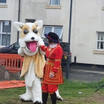 lady dressed as a queens beefeater guard and someone in a corgi costume as part of jubilee theatre