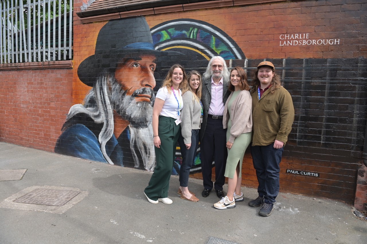 mural on wall with five people stood in front