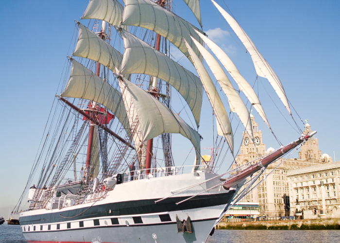 Tall ship Prince William sailing past the Three Graces on the River Mersey