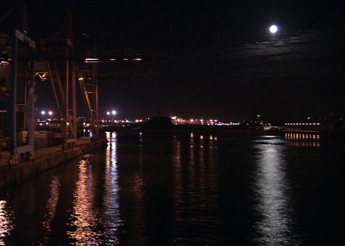 docks at night with the moon reflected in the water