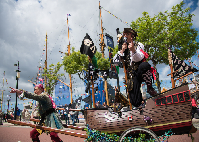 people dressed up in pirate costumes walking around with a boat