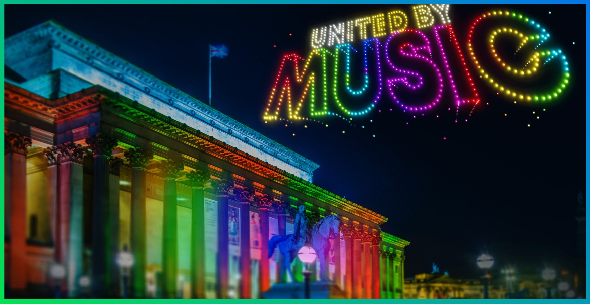 St George's Hall is lit up in multi-coloured lights with the words 'United by music' written in multi-coloured lights in the sky.
