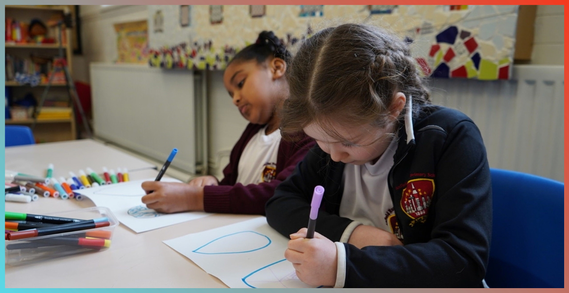 Two primary school pupils in class drawing on paper.