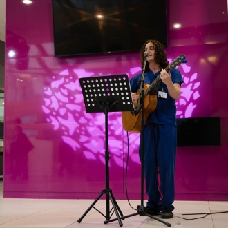 A nurse playing guitar and singing.