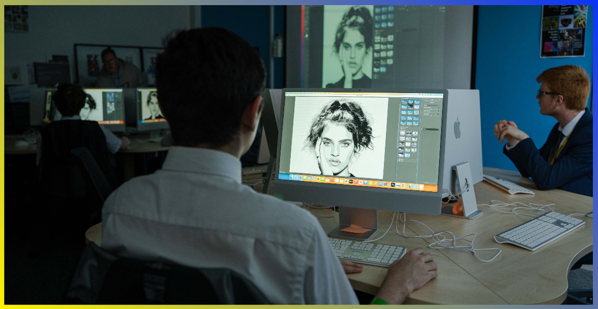 A student photoshops a black and white image in a class room.