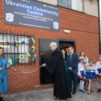 A man cutting the rope to open the Ukrainian Community Centre.