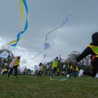 Primary school pupils flying kites.