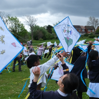 Primary school pupils flying kites.