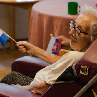 Care home resident waving a handheld flag.