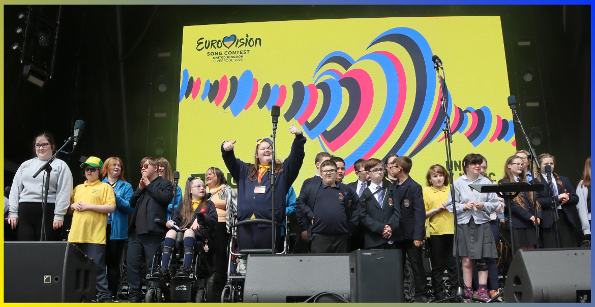 The Unity Through Song choir singing on stage at the Eurovision Village.