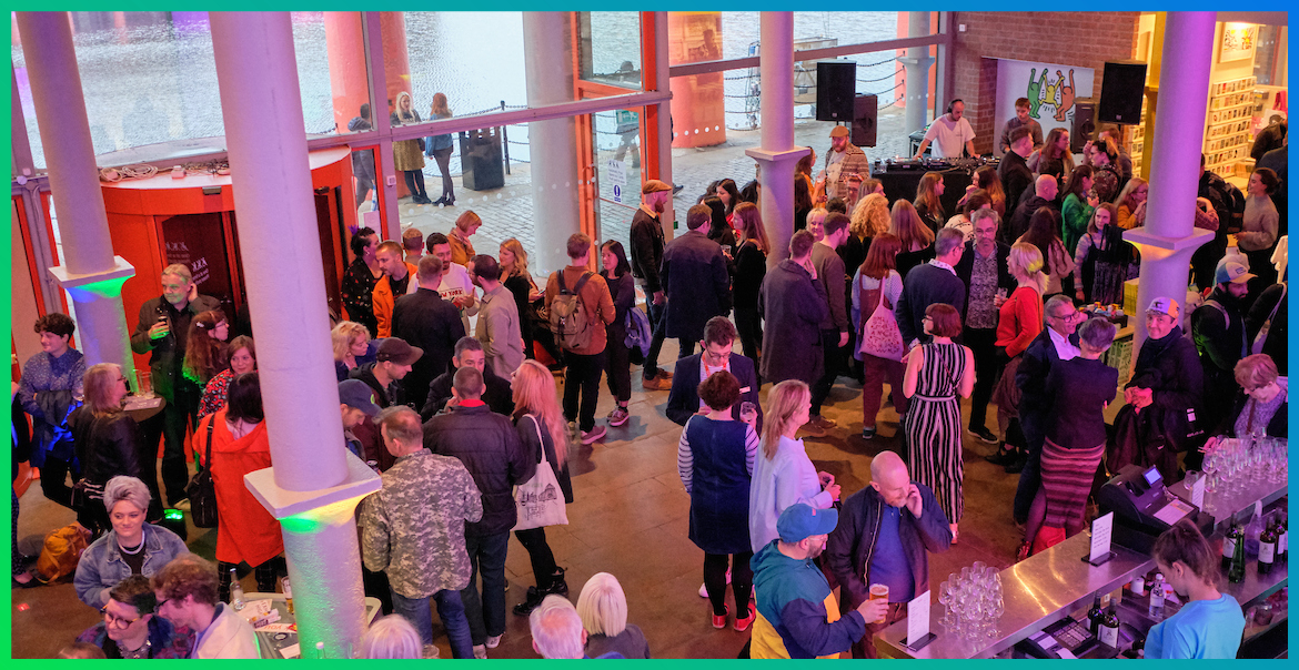 The foyer of Tate Liverpool busy with crowds at an evening event.
