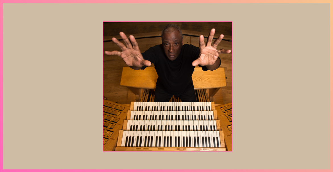 Image of Wayne Marshall OBE sitting in front of an organ