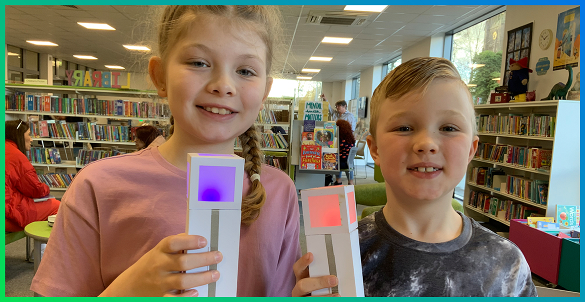 two children, a boy and a girl, holding a Minecraft torch in a library