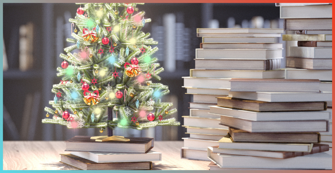 A small christmas tree next to a pile of books.