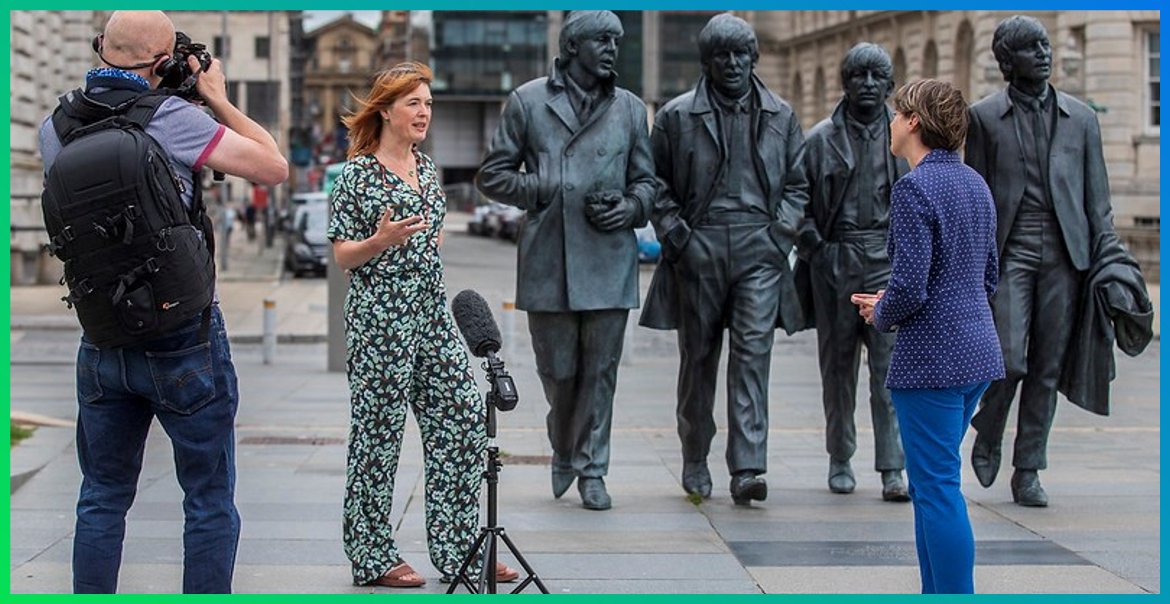 Claire McColgan CBE being interviewed by press in front of the Beatle Statues on Liverpool' Waterfront