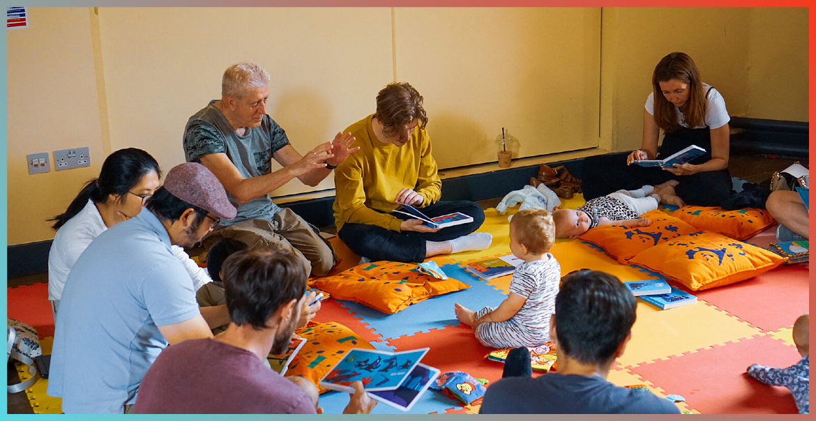 Adults and babies taking part in a baby book club.