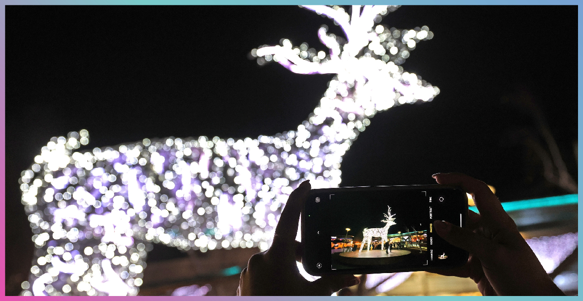 Somebody taking a photo of a sparkly deer Christmas light.
