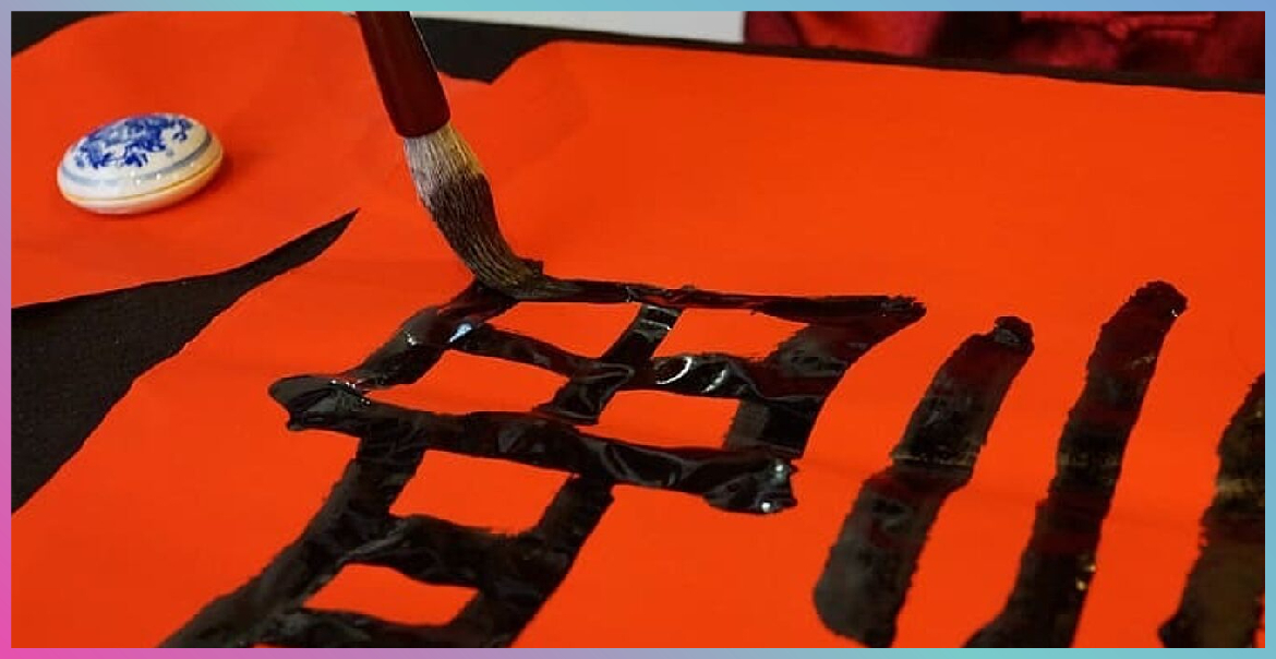 A close up image of somebody painting Chinese calligraphy.