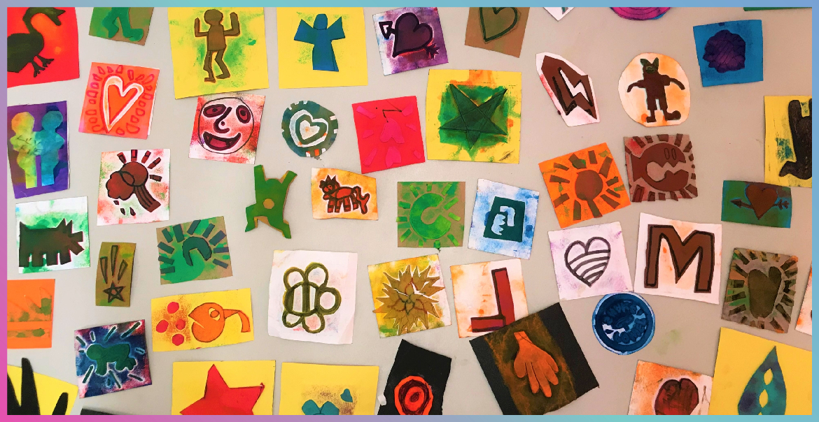 A collage of children's artwork on a wall.