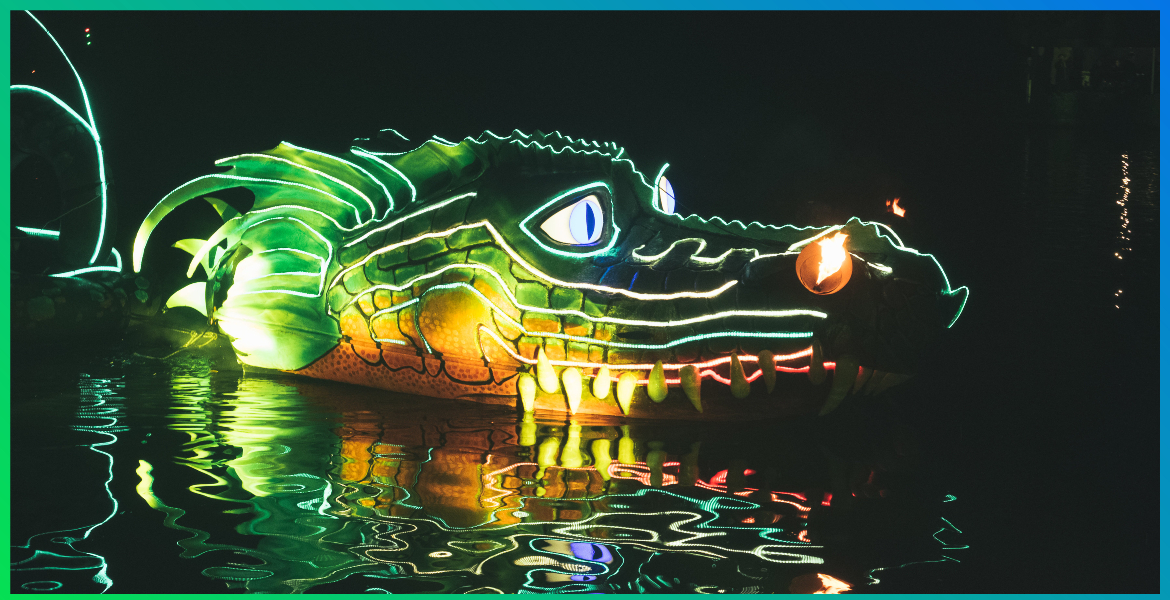 A lit-up dragon figure floating in water.