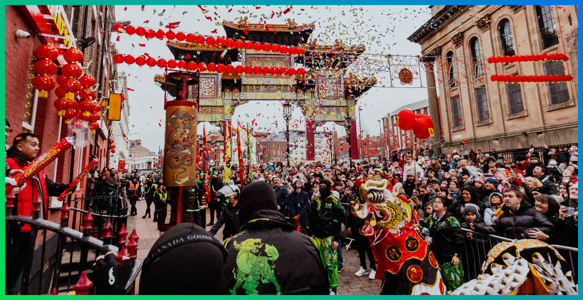 a crowd gathered in Liverpool's China Town in from of the Chinese Arch watching the Unicorn bless a local restaurant as part of the Lunar New Year celebrations