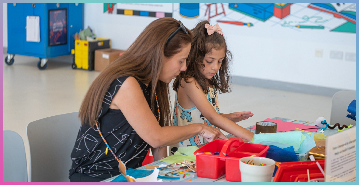 An adult and child doing a craft activity together.