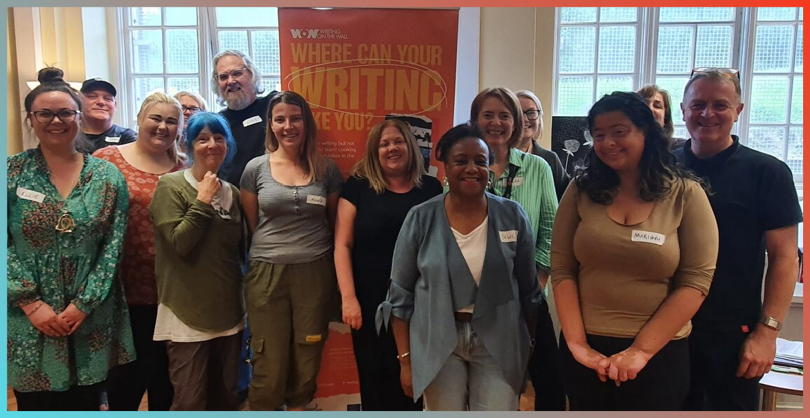 A group of participants of the Write to Work group standing together and smiling at the camera.