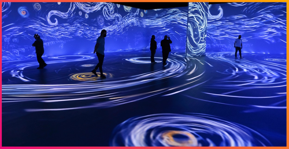An immersive art gallery with blue swirls projectd onto the walls and floor.
