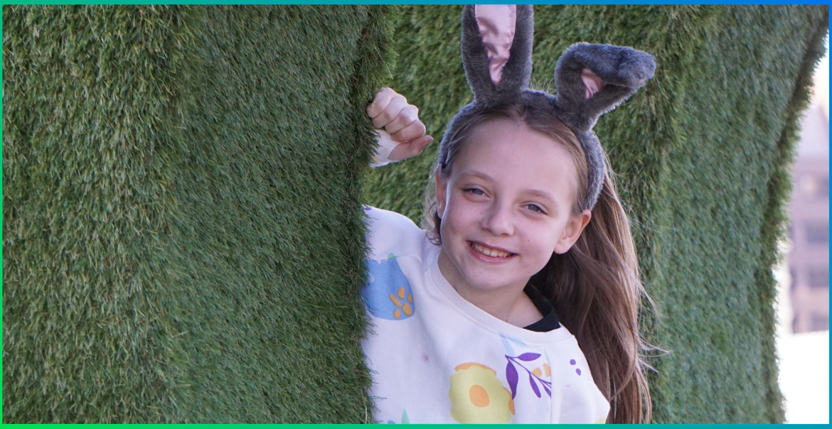 A young girl wearing easter bunny ears.
