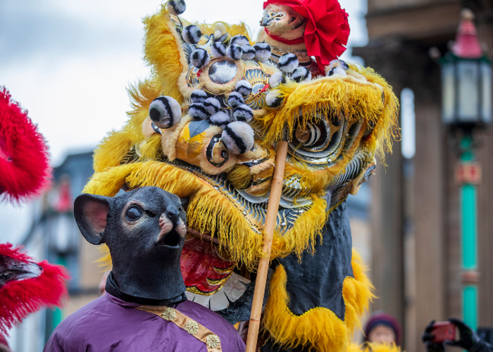 colourful picture of the Chinese New Year dragon alongside a person dressed as a rat to celebrate the Year of the Rat