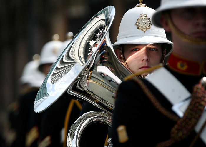 serviceman in uniform holding a French horn as he takes part in the tri-service parade in Liverpool