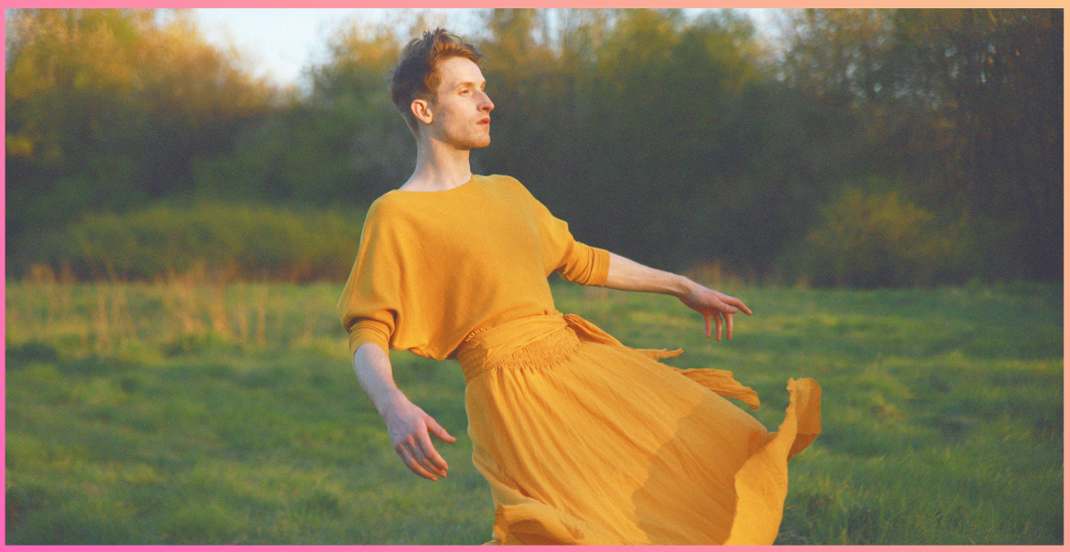 A person wearing a yellow flowy dress in a field.