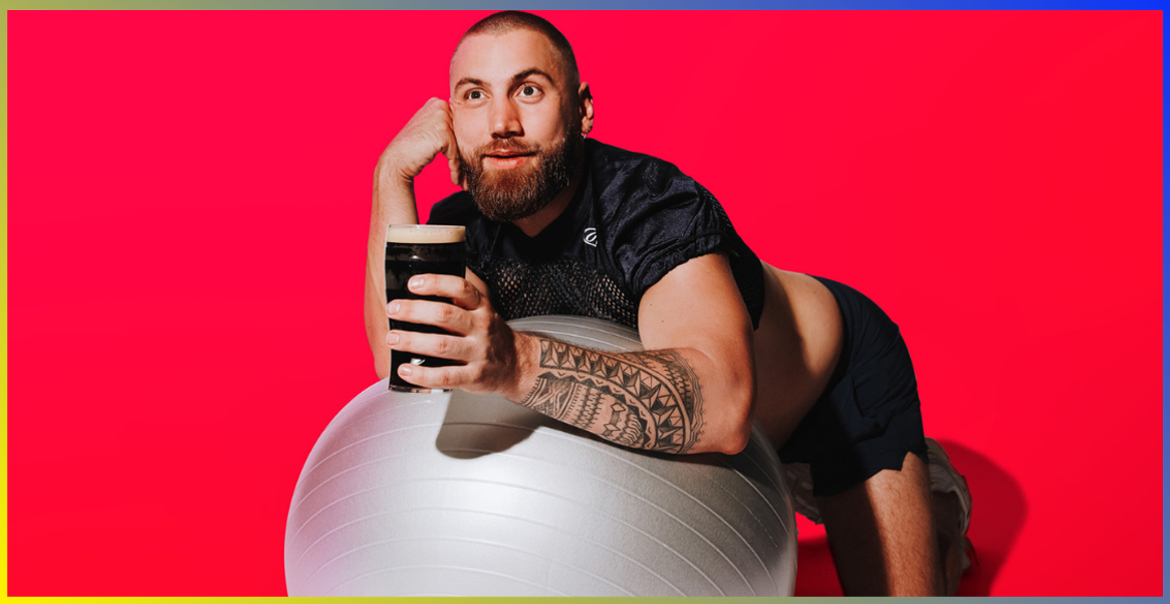 Morgan Rees leaning on a yoga ball holding a pint of Guiness.