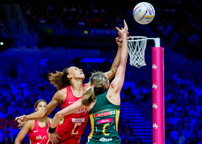 England v South Africa netball match in Liverpool with two ladies elevated in the air trying to shoot the ball into the hoop
